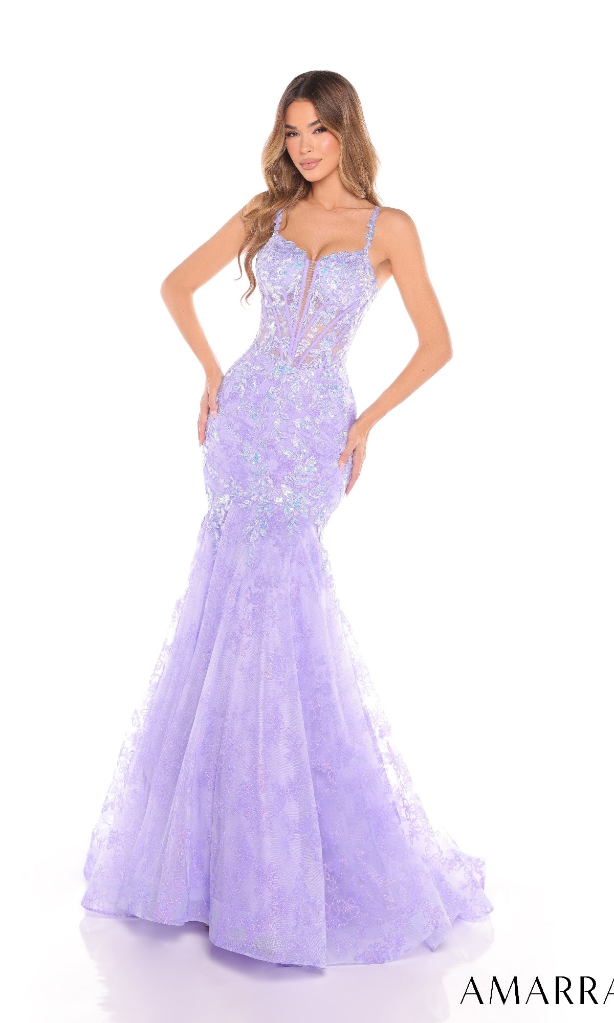 A woman wears the Amarra 88373, a fitted, floor-length lavender mermaid prom dress with a corset bodice, floral lace detailing, and thin straps, standing against a white background.